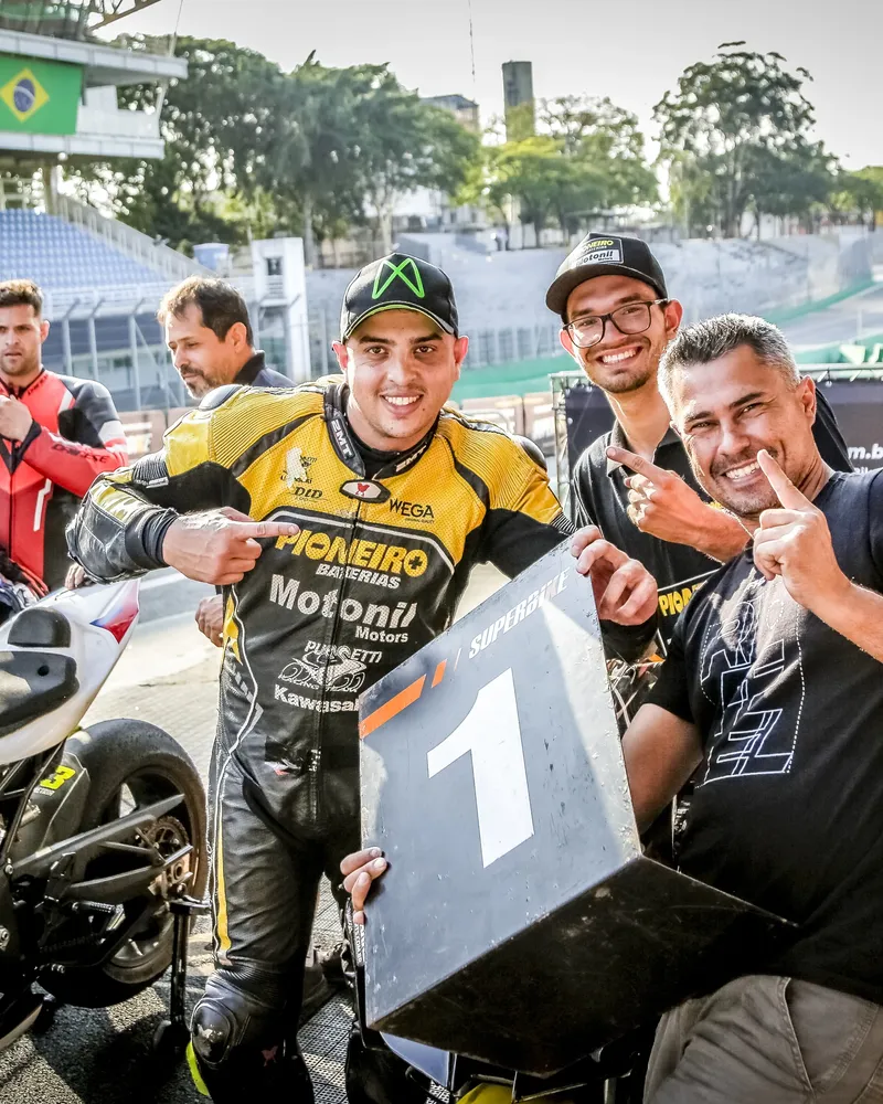 Gustavo Gão e a equipe comemorando com a placa de primeiro lugar